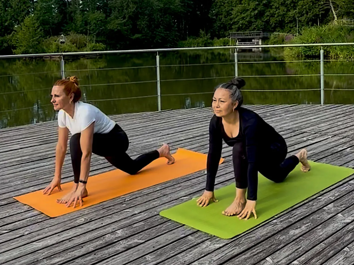 Sonia und Jeanna im tiefen Ausfallschritt auf einem Holzsteg am See