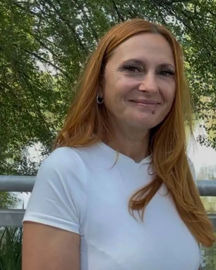 Porträt von Sonia Schmid-Greco mit roten Haaren und weißem Shirt