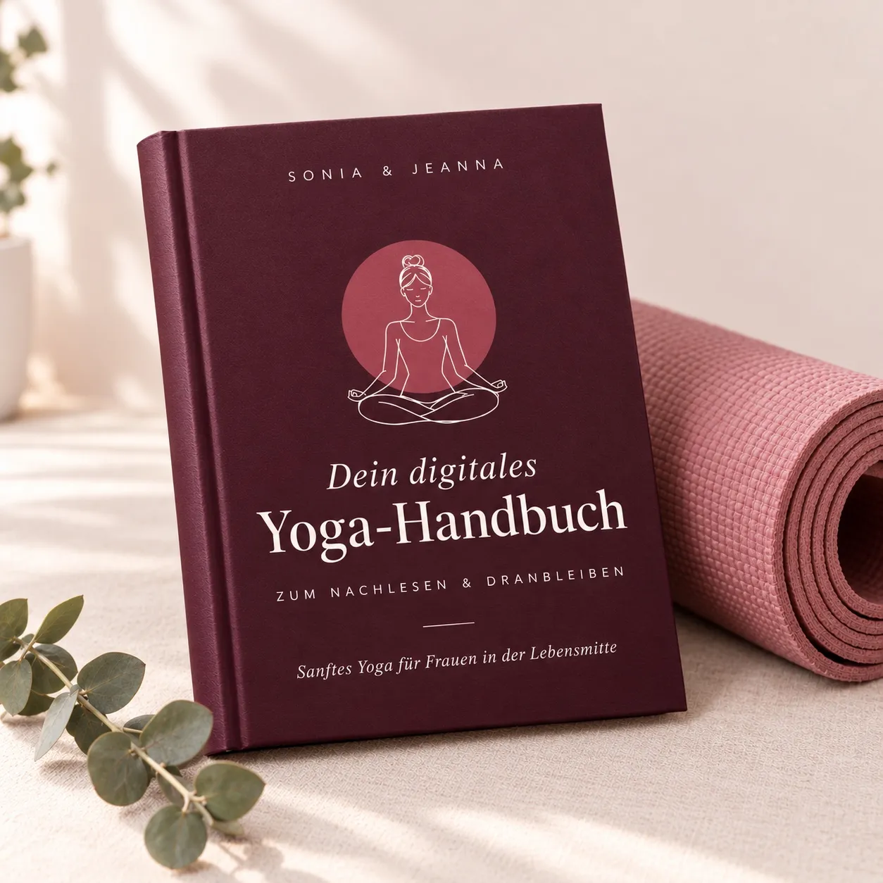 Das digitale Yoga-Handbuch von Sonia & Jeanna neben einer rosé Yogamatte